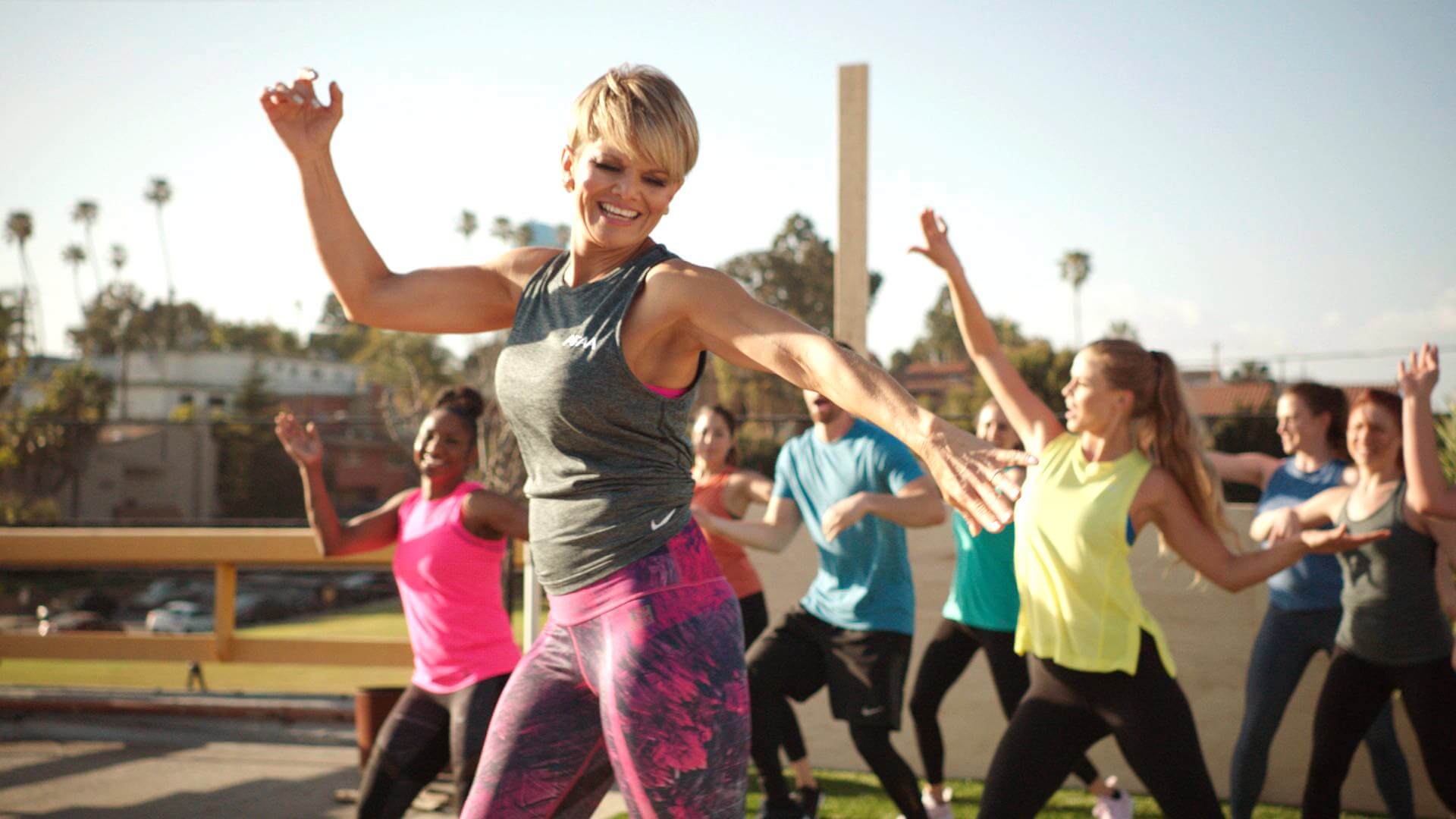 AFAA Certified Female Group Fitness Instructor Teaching Zumba Class On A Rooftop